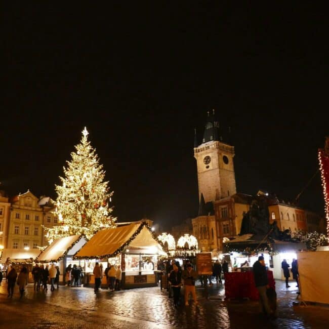 Christmas market with decorated tree at night in Prague
